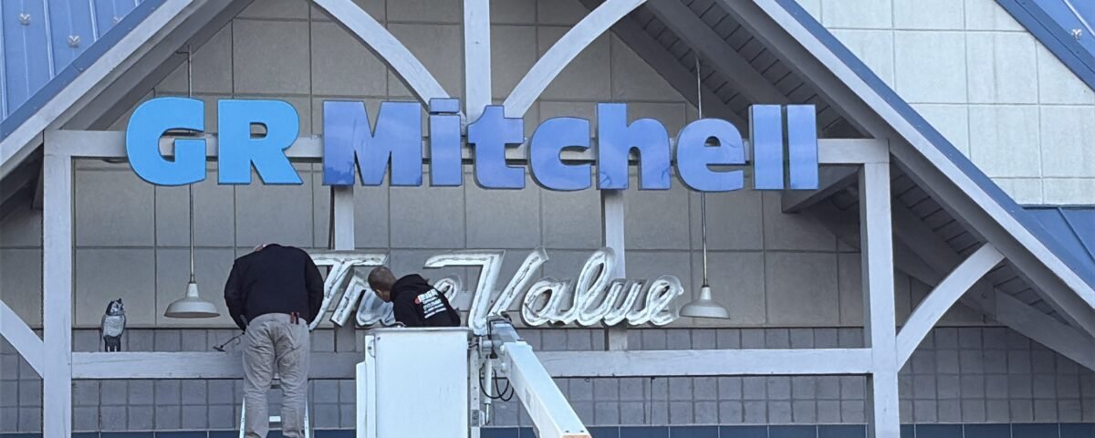 GR Mitchell taking down True Value sign from hardware storefront