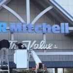 GR Mitchell taking down True Value sign from hardware storefront