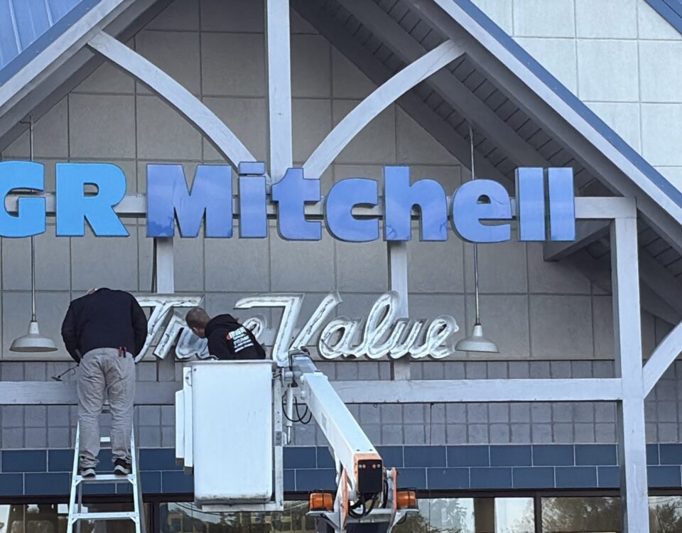 GR Mitchell taking down True Value sign from hardware storefront